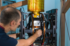 Working on a coil of an MRI scanner.